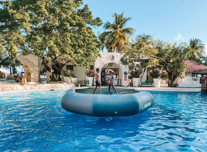 Lobby de hotel con flores, sillones y piso brilloso