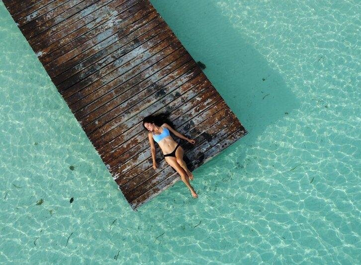 Lobby de hotel con flores, sillones y piso brilloso