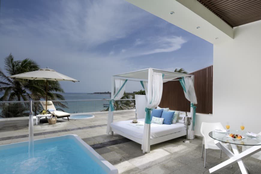 Sala en Master Suite con sillones, mesa, sillas y mini bar en hotel The Sian Ka'an at Grand Tulum