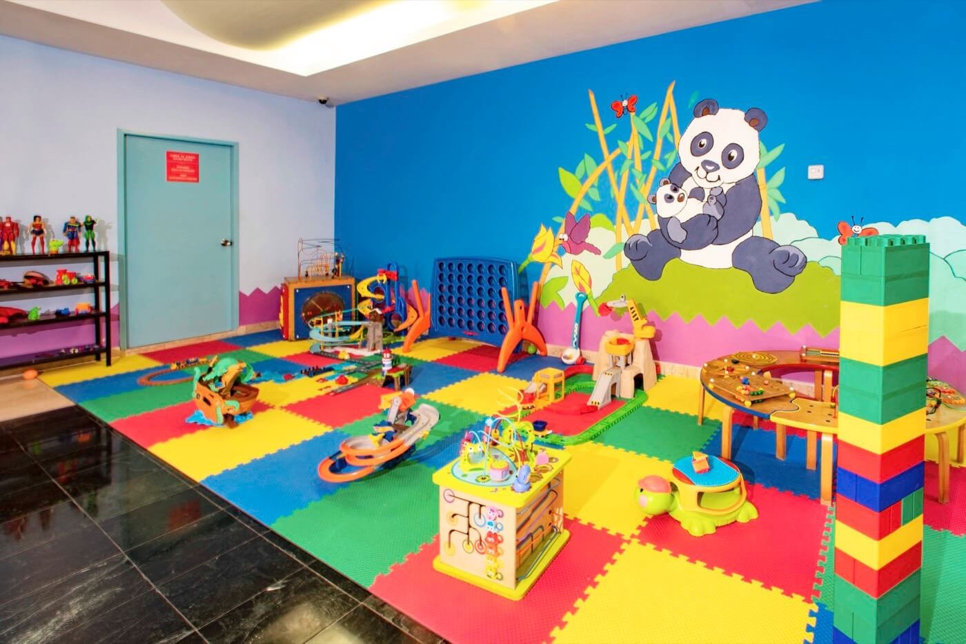 Área de juegos en KiddoZone con consolas y sillones puff en Hotel Grand Oasis Palm