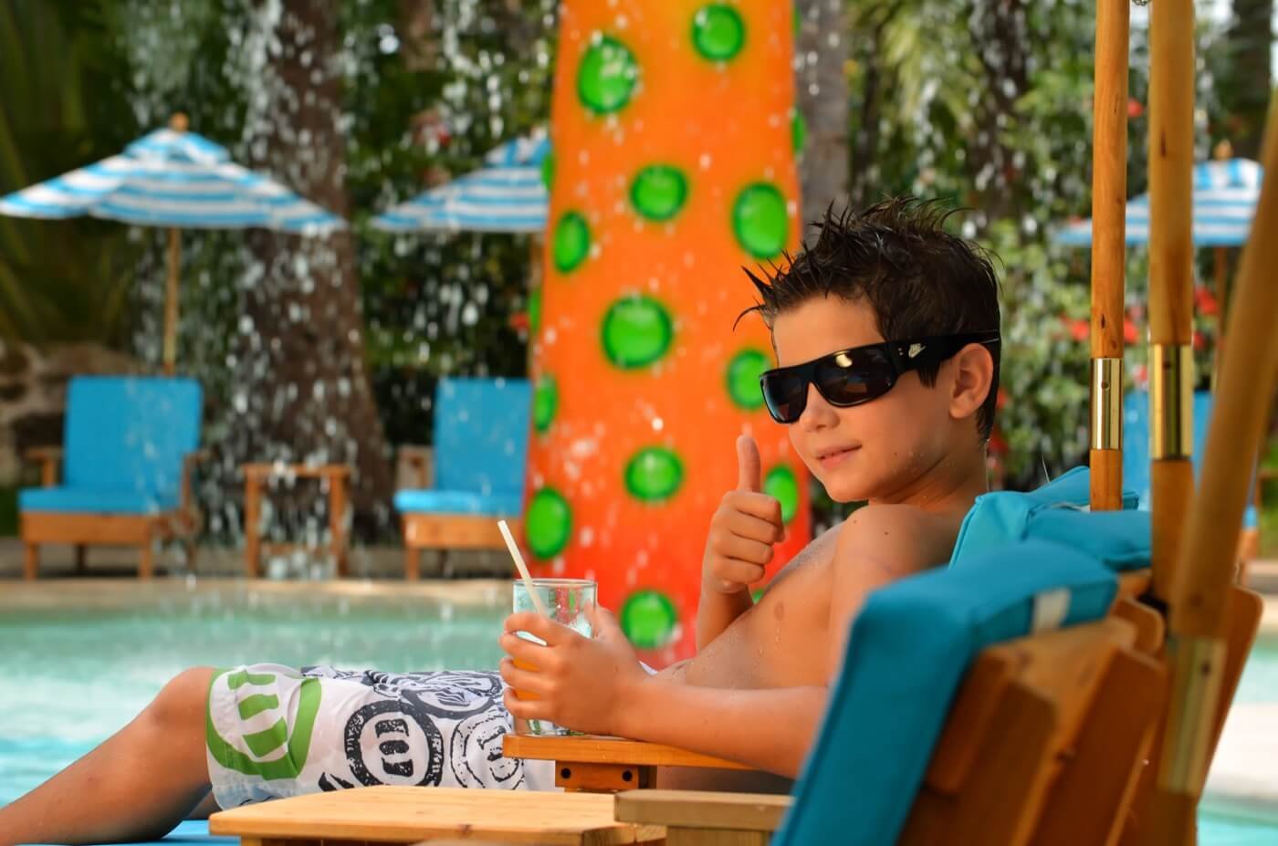 Área de juegos en KiddoZone con consolas y sillones puff en Hotel Grand Oasis Palm